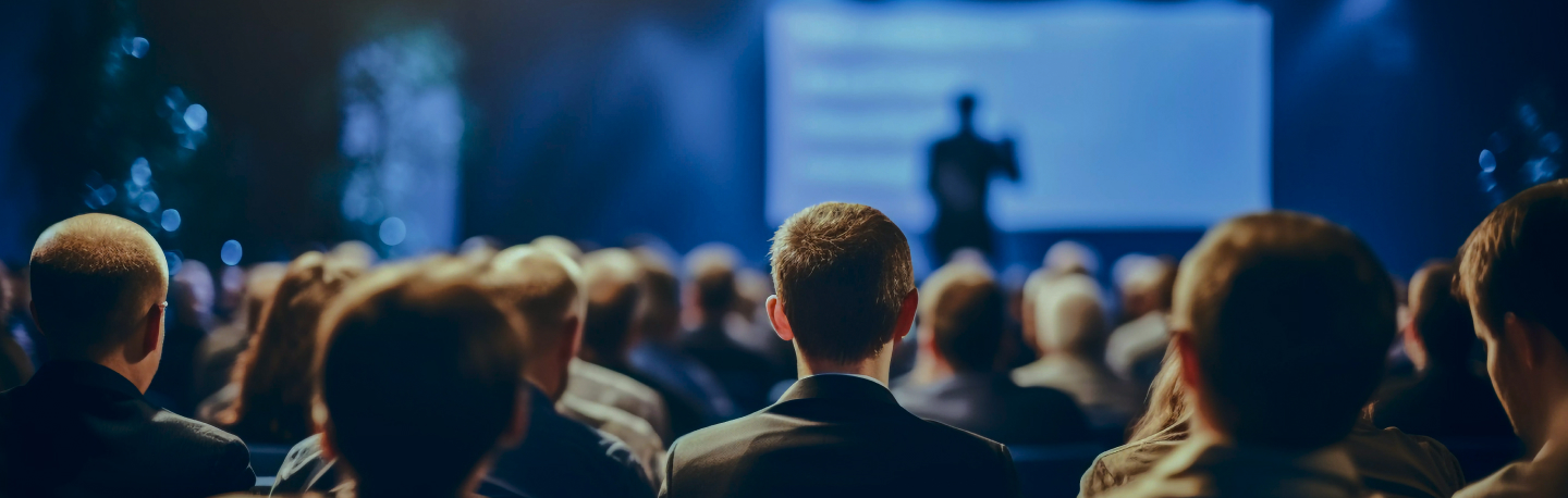 Audience watching a presentation at the conference auditorium